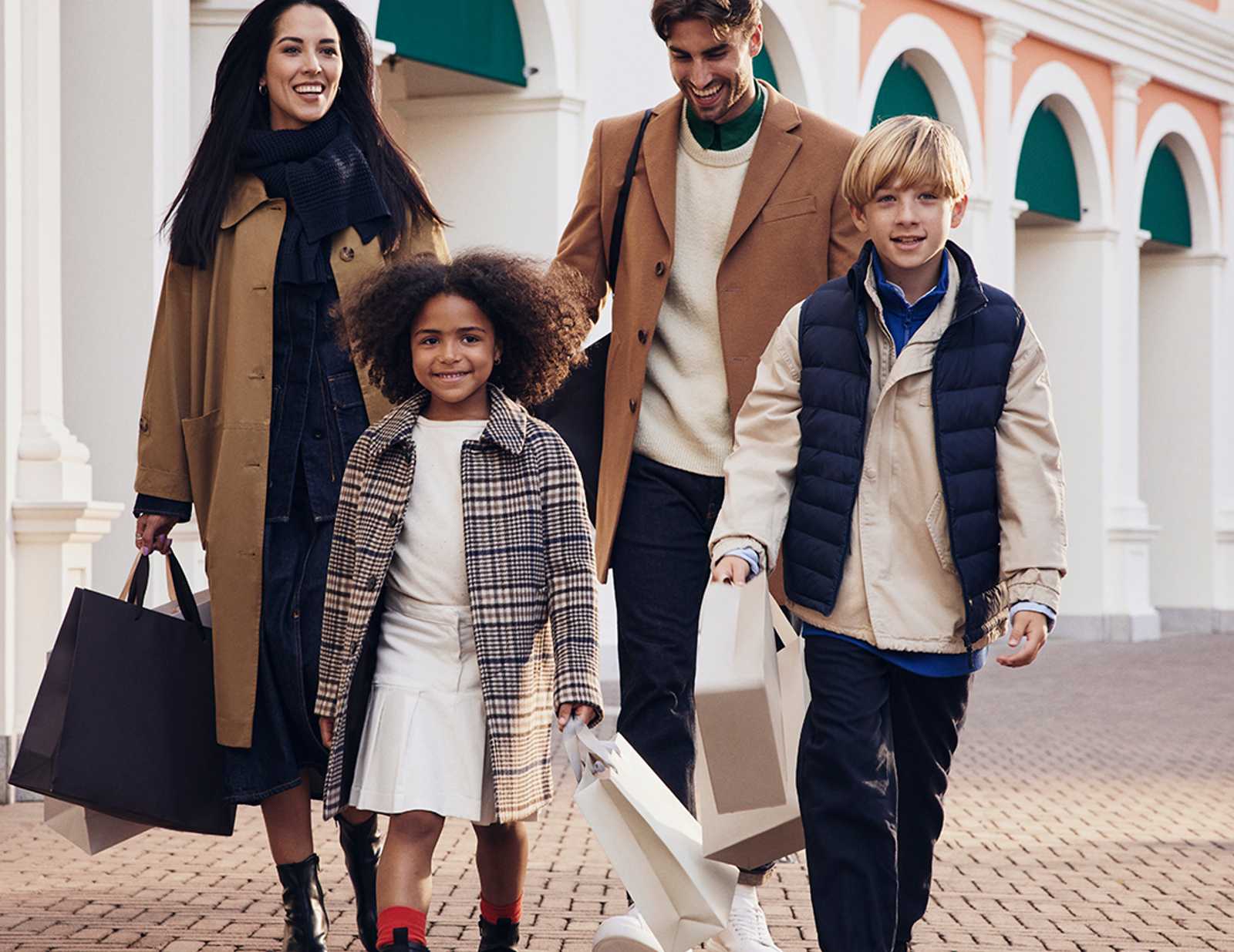 A happy family walking with shopping bags and their dog